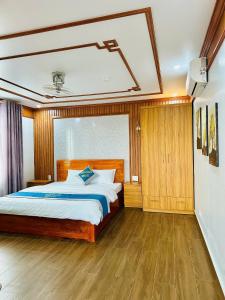 a bedroom with a large bed and wooden floors at Hải Phát Hotel in Thái Nguyên