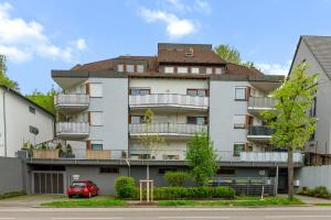 an apartment building with a red car parked in front at Design-Wohnung Ludwigsburg in Ludwigsburg
