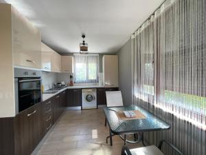 a kitchen with a table and a dining room at Къща за гости, Guesthouse GOTINOTO in Krapets