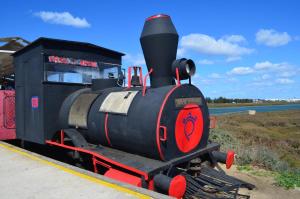 a black and red train sitting on the tracks at Santa Luzia Apartment in Santa Luzia