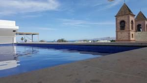 einem Pool vor einem Gebäude mit einem Uhrturm in der Unterkunft Hotel Catedral La Paz in La Paz