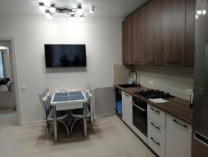 a kitchen with a table with chairs and a stove at Люкс залізничний вокзал in Luts'k