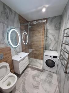 a bathroom with a toilet a sink and a shower at Люкс залізничний вокзал in Luts'k