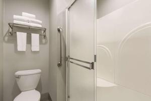 a bathroom with a shower and a toilet and towels at Super 8 by Wyndham Eureka in Eureka +40 photos