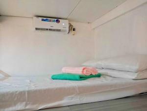 ein Krankenzimmer mit einem Bett, auf dem Handtücher liegen in der Unterkunft NM Homestay in Tayabas