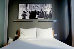 a bedroom with a white bed with a picture on the wall at I'zaz Lofts in Istanbul