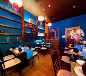 a dining room with tables and chairs and blue walls at Fairway Colombo - Sri Lanka's First Hotel With Robot Technology in Colombo