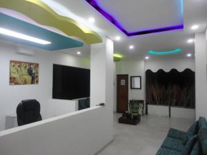 ein Wohnzimmer mit einem TV und einem Sofa in der Unterkunft Brizzamar Hotel in Santa Marta