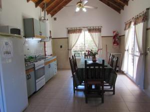 a kitchen with a table and chairs and a kitchen with a table and a table at Cabañas El Maiten in Merlo