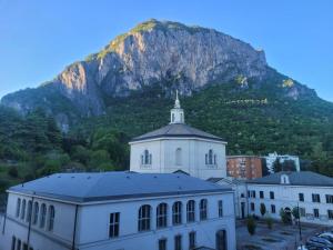a white building with a mountain in the background at Focolare Manzoni in Lecco