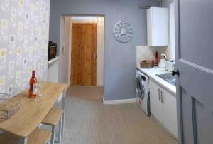 a kitchen with a table and a stove and a refrigerator at Westerleigh Annexe - Self-contained accommodation in Langport +14 photos