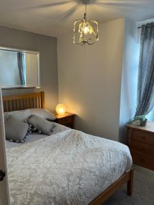 a bedroom with a bed and a chandelier at Westerleigh Annexe - Self-contained accommodation in Langport