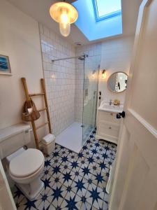 a bathroom with a shower and a toilet and a sink at Bungalow by the Sea, Moelfre in Moelfre +31 photos