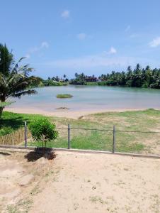 een uitzicht op een strand met een hek bij Crush River Villa Hikkaduwa in Hikkaduwa