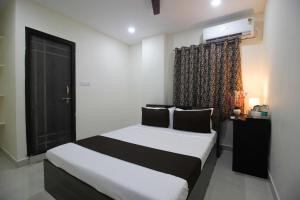 a bedroom with a bed and a window with a television at Collection O Stayo in Hyderabad