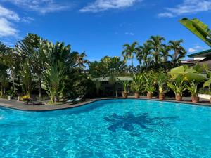 a large swimming pool with palm trees and a blue sky at Oasis Hotel in Angeles