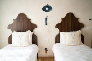 two beds with white sheets and wooden headboards at Porumbacu134 in Porumbacu de Sus