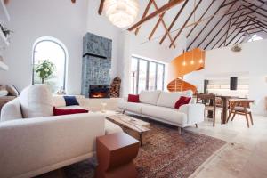 a living room with white furniture and a fireplace at Porumbacu134 in Porumbacu de Sus