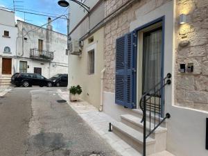 a building with a blue door and stairs on a street at Suite & Spa La Petra in Ceglie Messapica