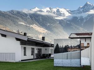 a white house with mountains in the background at Chalet Pirchhof inklusive Sauna in Sautens