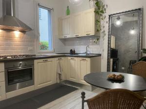 a kitchen with white cabinets and a table and a window at Casa Rossana - 15min from Venice in Mestre
