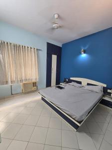 a bedroom with a large bed in a blue wall at Blue Haven Villa - Luxurious 3BHK Stay in Jodhpur +12 photos