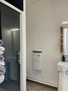 a bathroom with a towel dispenser on the wall at Chez Louis in Saint-Flour +40 photos