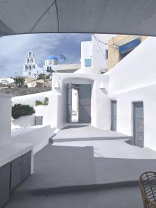 une vue d'un bâtiment blanc avec une porte dans l'établissement Imarkellis Pyrgos Cave and Belfry Charm Santorini, à Pyrgos