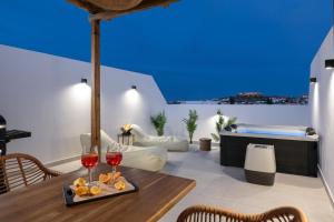 a living room with a table and two glasses of wine at Onar -Quiet Luxury Suites with Private Jacuzzi-Ideal for Couples in Archangelos