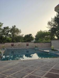 a swimming pool in a yard with a brick wall at Blue Haven Villa - Luxurious 3BHK Stay in Jodhpur