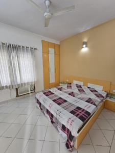 a bedroom with a bed with a plaid blanket at Blue Haven Villa - Luxurious 3BHK Stay in Jodhpur