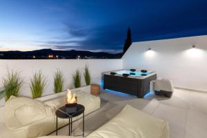 a living room with a couch and a fireplace at Onar -Quiet Luxury Suites with Private Jacuzzi-Ideal for Couples in Archangelos +31 photos