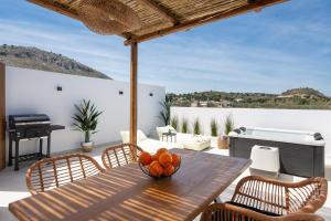 a table with a bowl of oranges on a patio at Onar -Quiet Luxury Suites with Private Jacuzzi-Ideal for Couples in Archangelos
