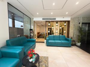 a lobby with blue couches and a table at Hotel Landridge - HITECH City Hyderabad in Hyderabad +84 photos