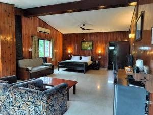 a living room with a bed and a couch at River Access Resorts by Bel-La Monde - "A Unit of Luxe Opera Hotels & Resorts", Dhikhuli Jim Corbett, Uttarakhand in Garjia