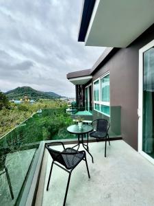 a patio with a table and chairs on a balcony at 1BR Luxury The City Phuket in Ban Ket Ho