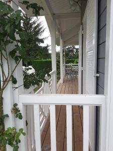 a porch with white railings and a white fence at Maison proche du Bassin d'Arcachon in Salles
