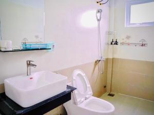 a bathroom with a white sink and a toilet at LƯNG CHỪNG Home in Xuan An +25 photos