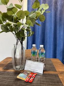 a table with a vase and two bottles of water at Modern Style Village House in Kuching