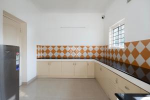 a kitchen with white cabinets and a window at ECR INN - Premium 3BHK Beach Villa, Cheyyur in Cheyūr