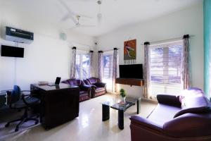 a living room with couches and a flat screen tv at ECR INN - Premium 3BHK Beach Villa, Cheyyur in Cheyūr