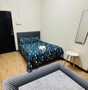 a bedroom with a bed and a table and a mirror at Wawa Homestay Bandar Jeli - 2 in Jeli