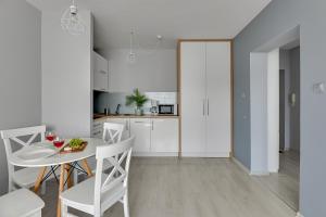 une cuisine et une salle à manger avec une table et des chaises dans l'établissement Central Apartment Gdynia by Lion Apartments, à Gdynia
