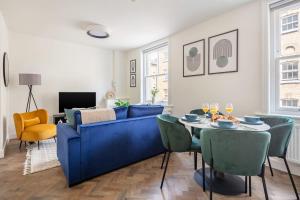 a living room with a blue couch and a table at BnBNova - 1BR - St Paul's & Barbican in London