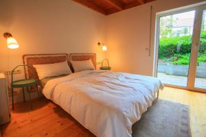 1 dormitorio con 1 cama grande, ventana y silla en Das kleine Paradies, en Markdorf