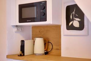 a microwave sitting on top of a wooden shelf at Cueva la Bonica - Hostatel in Granada