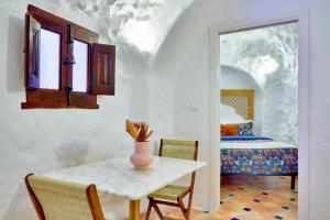 a table and chairs in a room with a bed at Cueva la Bonica - Hostatel in Granada