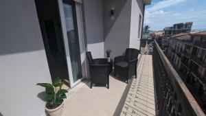 a balcony with chairs and a table on a building at Scirocco in Santa Teresa di Riva