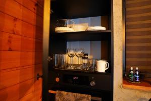 a shelf with wine glasses and dishes on it at Apartament Piorun in Mrągowo