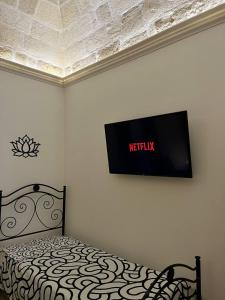 a bedroom with a bed with a television on the wall at Bien-être Exclusive Apartment in Taranto
